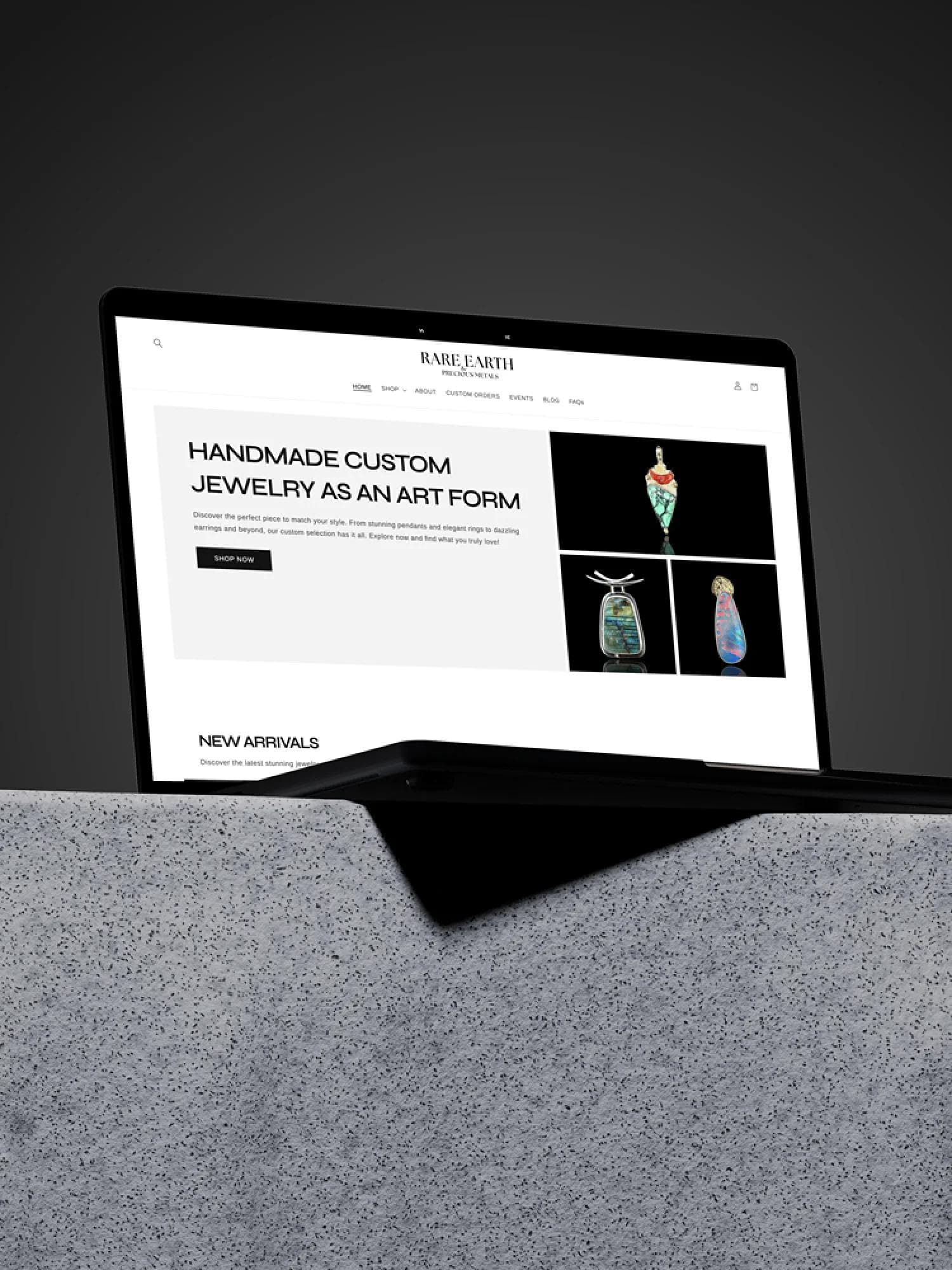 Rare Earth and Precious Metals website design pulled up on a laptop on top of a stone block