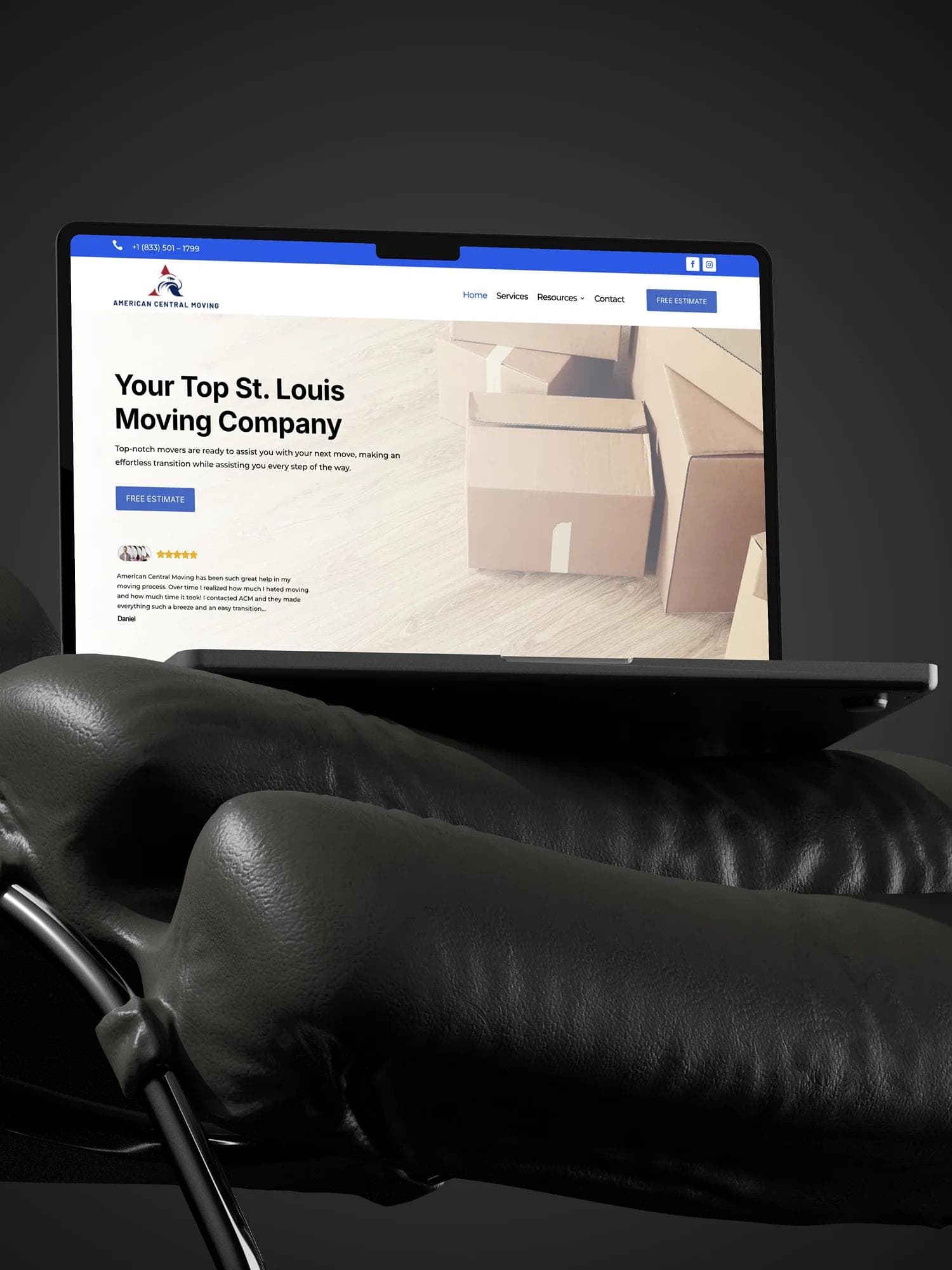 American Central Moving website design on a laptop sitting on a black couch.